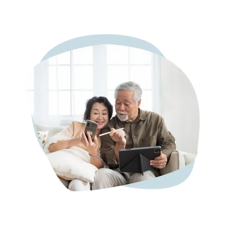 A couple on their sofa following along together on a tablet and phone